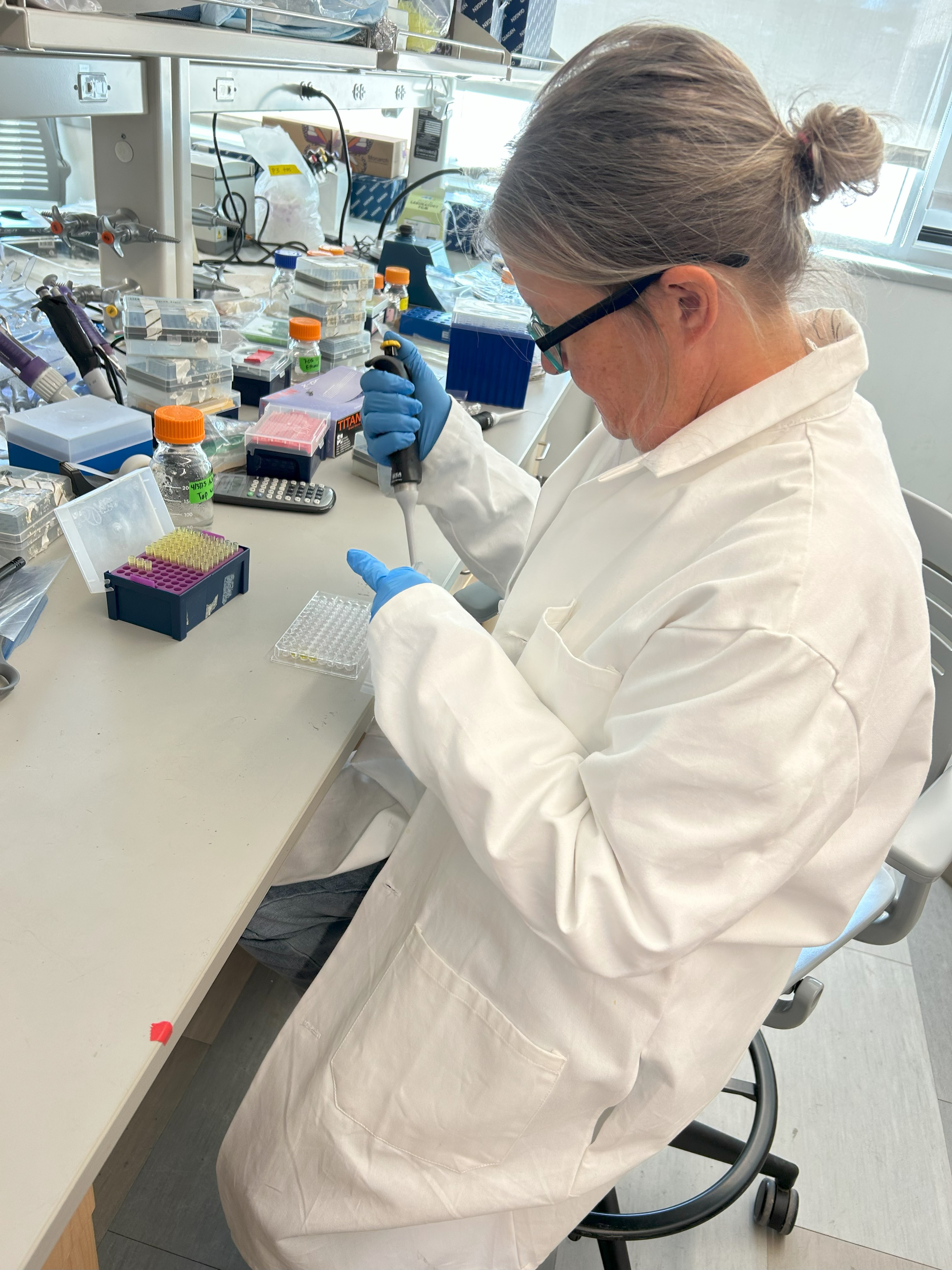 Plant diagnostician changing the tips out of a micropipette in a laboratory setting